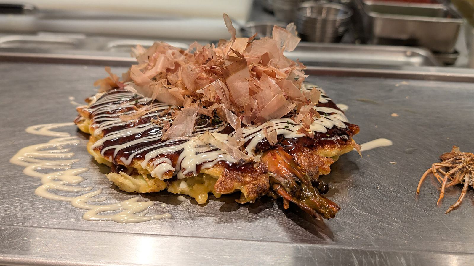 Okonomiyaki cooking on a hot plate in Osaka